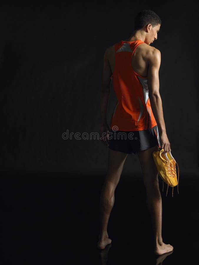 Full längd av den manliga idrottsman nen Holding Shoes royaltyfri fotografi