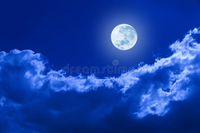 A full moon glowing in a night sky with clouds. A full moon glowing in a night sky with clouds