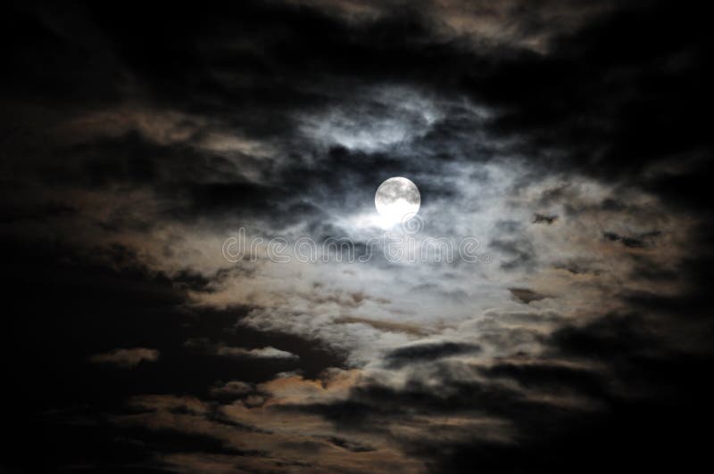 Full moon and white clouds on black night sky scene.