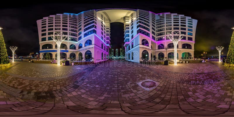 MINSK, BELARUS - JANUARY 2020: full seamless spherical hdri night panorama 360 near arch between multistory buildings of residential quarter with neon light in windows in equirectangular projection. MINSK, BELARUS - JANUARY 2020: full seamless spherical hdri night panorama 360 near arch between multistory buildings of residential quarter with neon light in windows in equirectangular projection