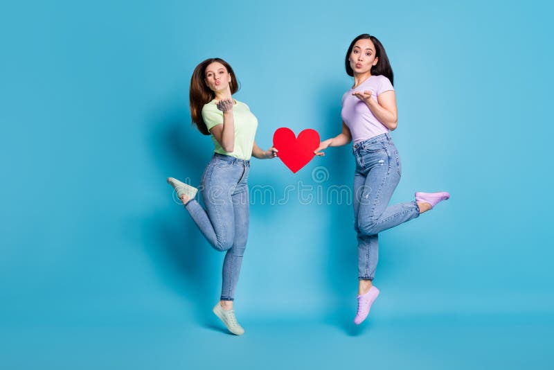 Full size photo of two people lesbians couple ladies jump high up hold big red paper heart valentine day celebration