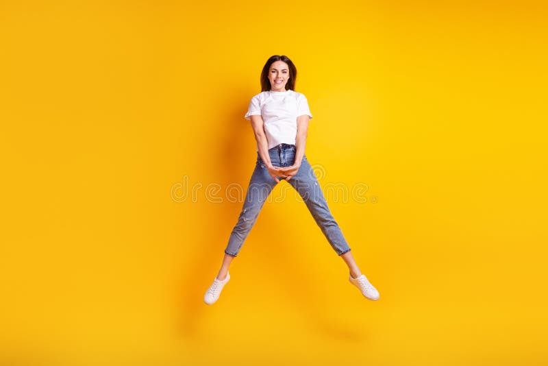 Full size photo of young pretty girl good mood jump up energetic isolated over yellow color background stock images