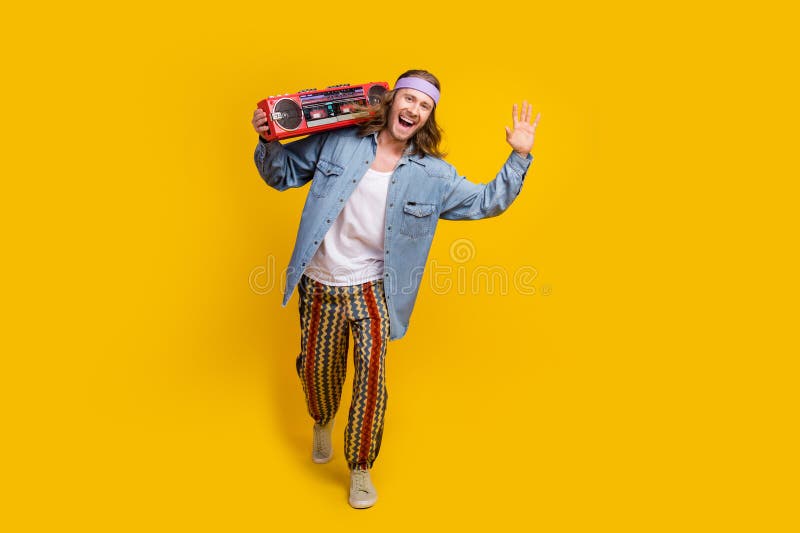 Full size photo of cool young man dance boombox empty space wear denim shirt isolated on yellow color background. Full size photo of cool young man dance boombox empty space wear denim shirt isolated on yellow color background.