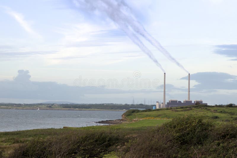 Fumes billowing from the power plant chimney stacks