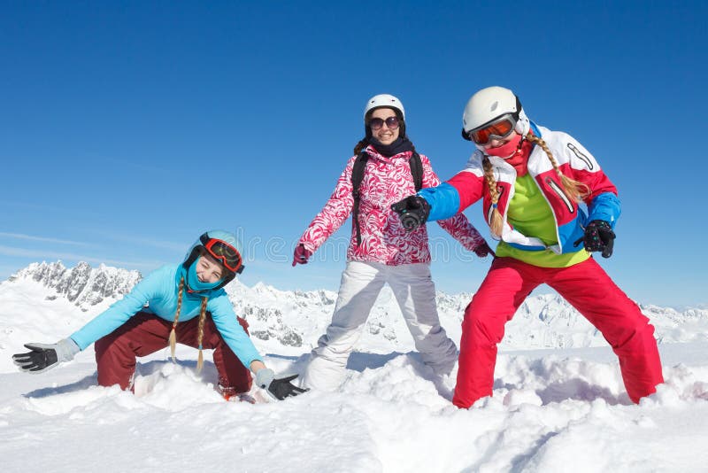 Fun activity in the snow. Three girls on winter vacation in the Alps playing in the snow on the ski slopes royalty free stock image Fun activity in the snow. Three girls on winter vacation in the Alps playing in the snow on the ski slopes royalty free stock image