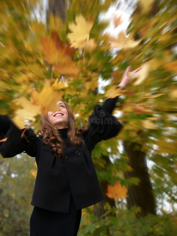 Fun girl tosses fall foliage