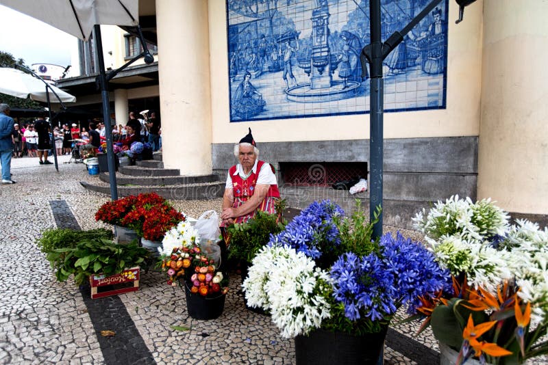 FUNCHAL, PORTUGAL - JUNE 29, 2015: A traditional woman sells flo stock photos FUNCHAL, PORTUGAL - JUNE 29, 2015: A traditional woman sells flo stock photos