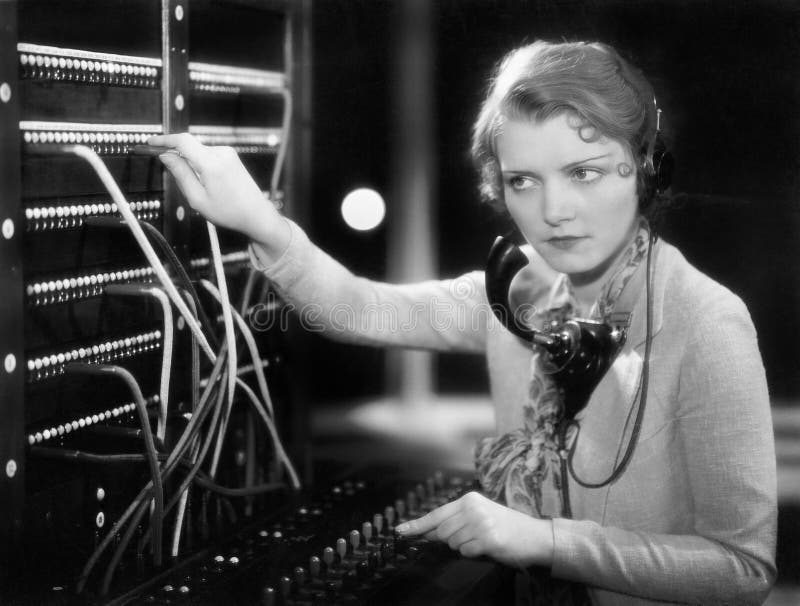 Funcionamiento de la mujer joven como telefonista (todas las personas representadas no son vivas más largo y ningún estado existe fotografía de archivo Funcionamiento de la mujer joven como telefonista (todas las personas representadas no son vivas más largo y ningún estado existe fotografía de archivo