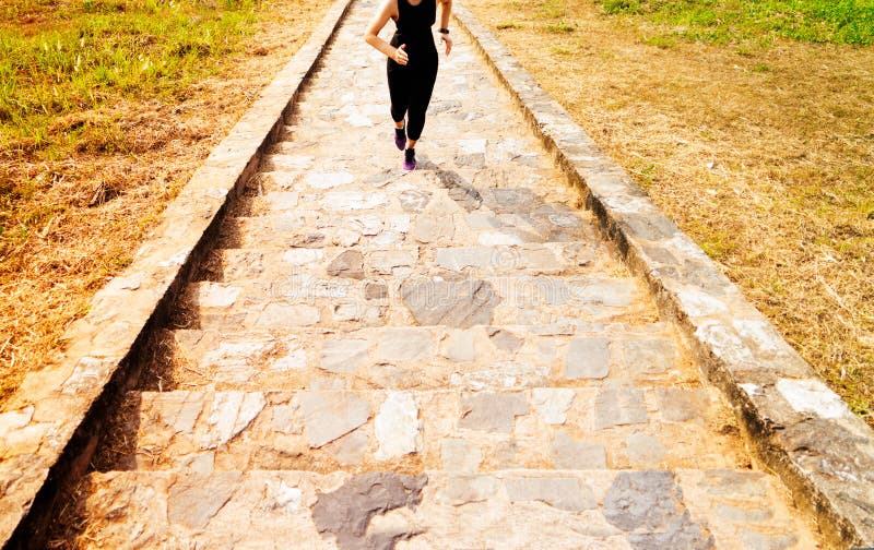 Funcionamiento joven de la mujer del deporte al aire libre arriba en el cielo azul imagenes de archivo Funcionamiento joven de la mujer del deporte al aire libre arriba en el cielo azul imagenes de archivo