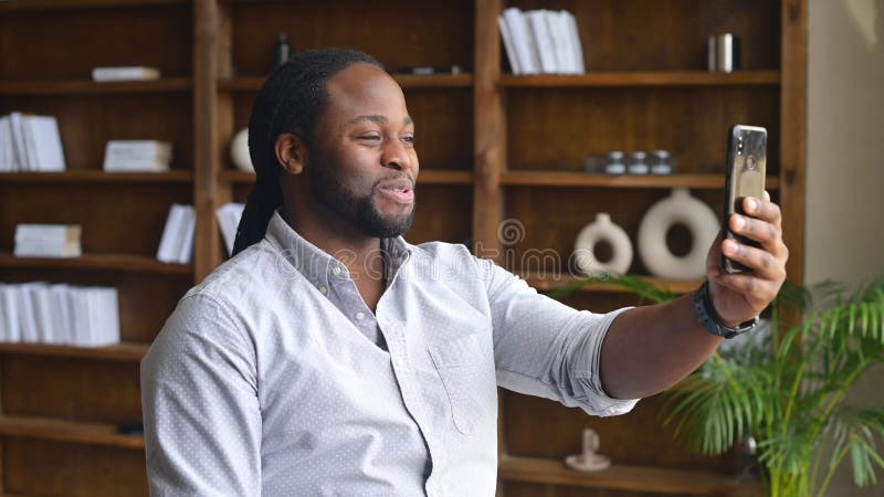 Funcionário de escritório africanamerico usando telefone para videocassar