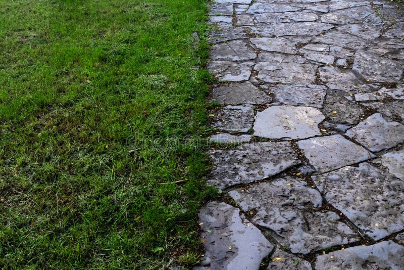 Fundalul este format din jumătate din iarba verde și jumătate din calea pietrei. stock photo