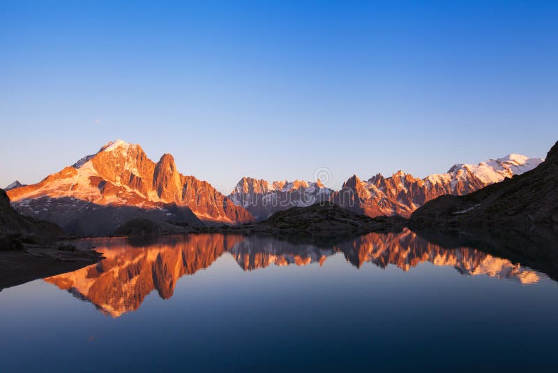 Beautiful nature background, mountain landscape at sunset, panoramic view of Alps with reflection in lake. Beautiful nature background, mountain landscape at sunset, panoramic view of Alps with reflection in lake