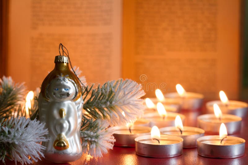 Fundo da Bíblia da árvore da quinquilharia e do Natal do sumário da vela na noite imagem de stock Fundo da Bíblia da árvore da quinquilharia e do Natal do sumário da vela na noite imagem de stock