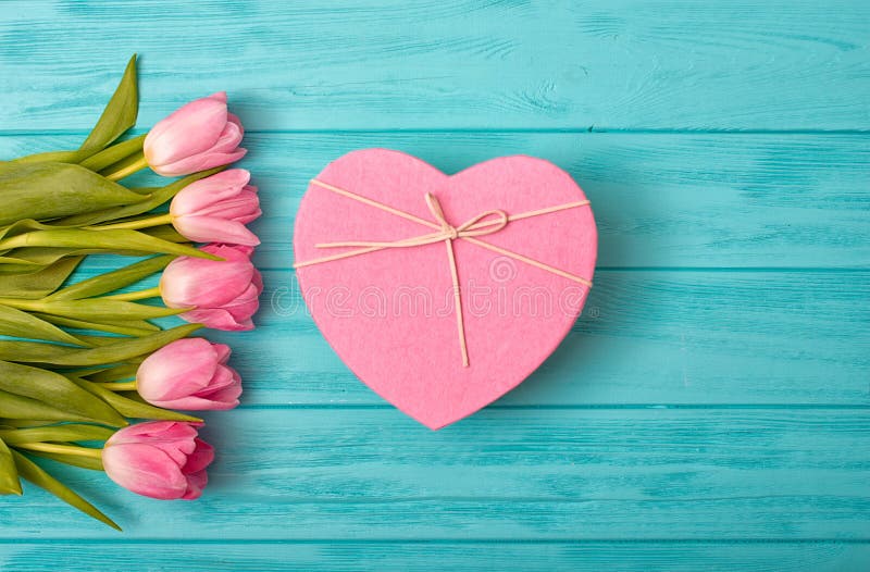 Fundo do dia de Valentim com ramalhete das tulipas e de uma caixa de presente na forma de um coração imagem de stock royalty free Fundo do dia de Valentim com ramalhete das tulipas e de uma caixa de presente na forma de um coração imagem de stock royalty free