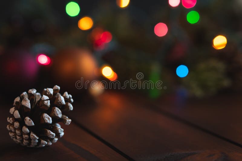Fundo do Natal com cone do pinho e fora das luzes e das decorações do foco com sala para o texto fotografia de stock Fundo do Natal com cone do pinho e fora das luzes e das decorações do foco com sala para o texto fotografia de stock