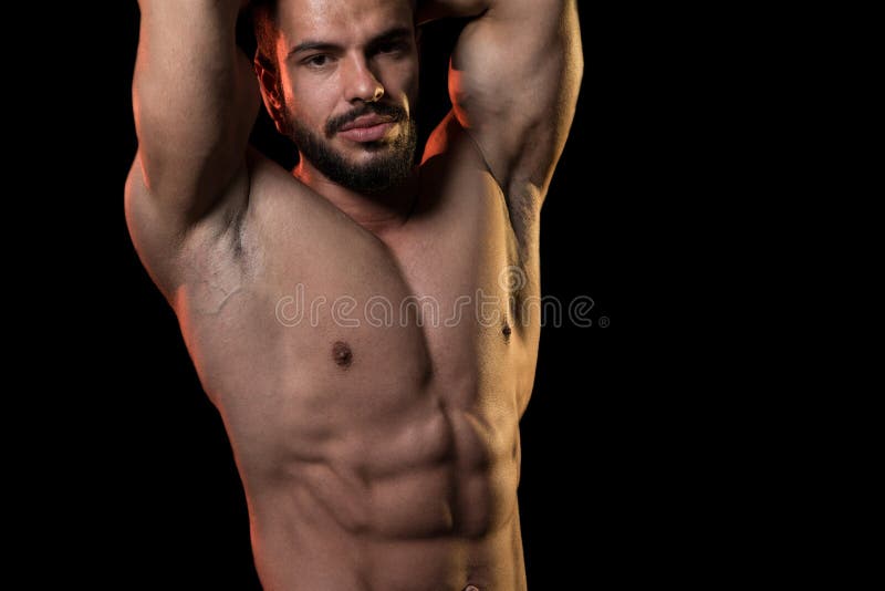 Modelo musculado a exibir os músculos sobre fundo preto imagens de stock
