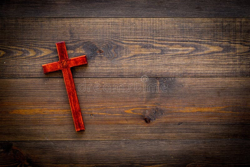 Funeral concept. Wooden cross on dark wooden background top view copy space