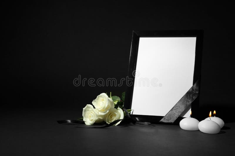 Funeral photo frame with ribbon, white roses and candles on background. Space for design