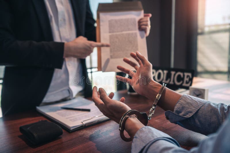 Police officer interrogating suspect or criminal man with handcuffs arrested at the investigation. Police officer interrogating suspect or criminal man with handcuffs arrested at the investigation.