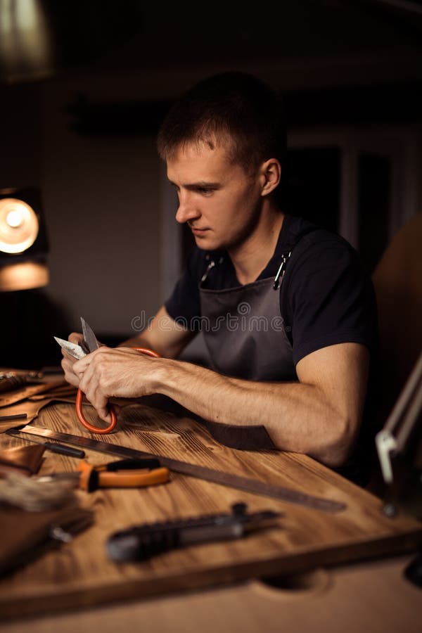 Funktionsduglig process av läderbältet i läderseminariet Maninnehav som tillverkar hjälpmedlet och arbete Garvare i gammalt royaltyfri foto Funktionsduglig process av läderbältet i läderseminariet Maninnehav som tillverkar hjälpmedlet och arbete Garvare i gammalt royaltyfri foto