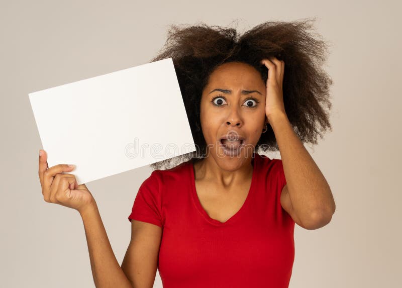 Funny african american woman holding blank board looking surprised and happy pointing at the add stock image Funny african american woman holding blank board looking surprised and happy pointing at the add stock image
