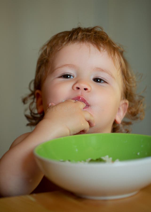 Funny Baby Eating Food Himself with a Spoon on Kitchen. Funny Child ...