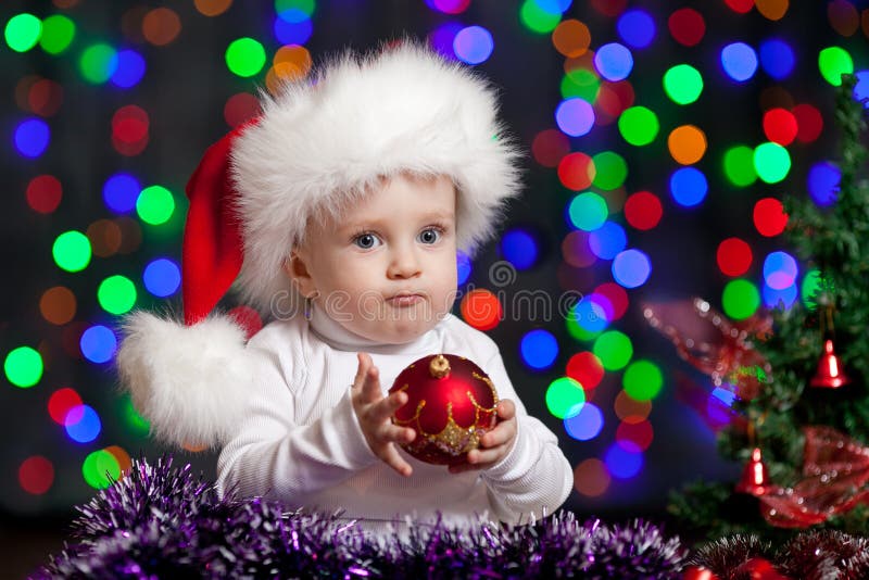 Funny baby in Santa hat on bright background