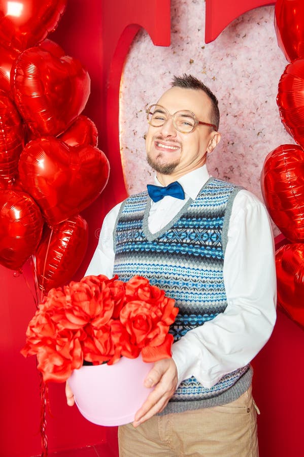 Funny Bearded Retro Style Man In The Blue Vest Holding Present Box On The Red Heart Shape