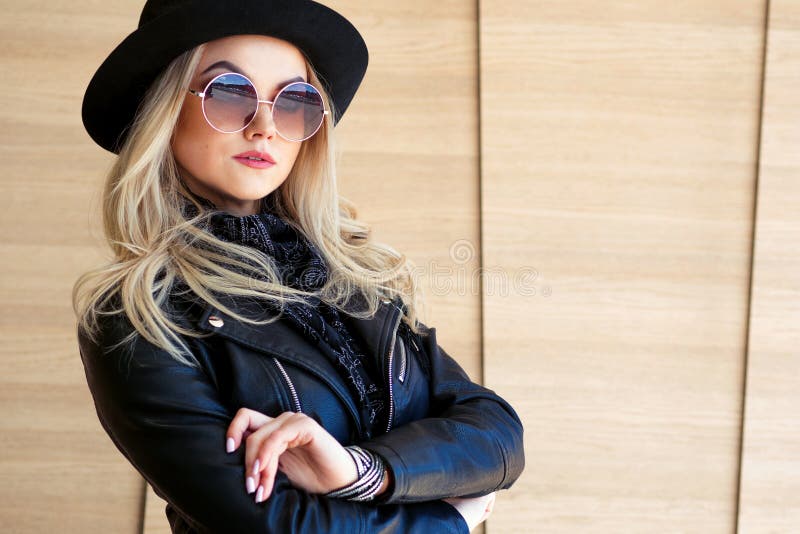 Funny and beautiful blonde in sun glasses and a hat. Trendy girl portrait outdoor. Holds hat royalty free stock photo Funny and beautiful blonde in sun glasses and a hat. Trendy girl portrait outdoor. Holds hat royalty free stock photo