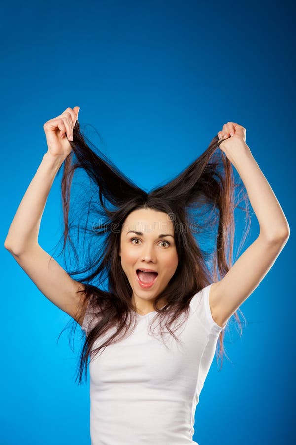 Funny beautiful brunette girl holding her long hair up