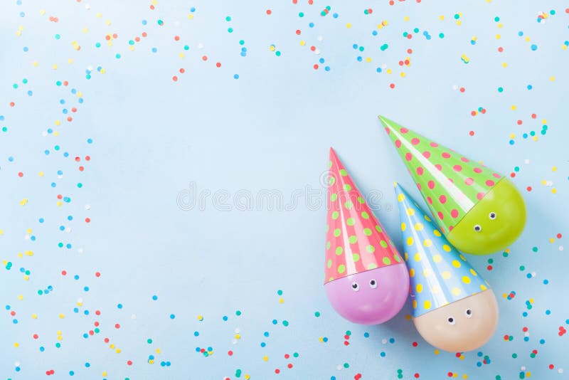 Funny birthday or party background. Colorful balloons and confetti on blue table top view. Flat lay style. Greeting card.