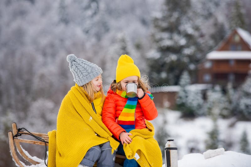 Funny boy and girl having fun with a sleigh in winter. Cute children playing in a snow. Winter activities for kids.