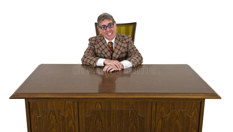 Funny businessman sits at office his desk and has a big smile on his face. He must love his job! The silly suit and tie add to the scene. The man must be a business nerd! Isolated on white. Funny businessman sits at office his desk and has a big smile on his face. He must love his job! The silly suit and tie add to the scene. The man must be a business nerd! Isolated on white.