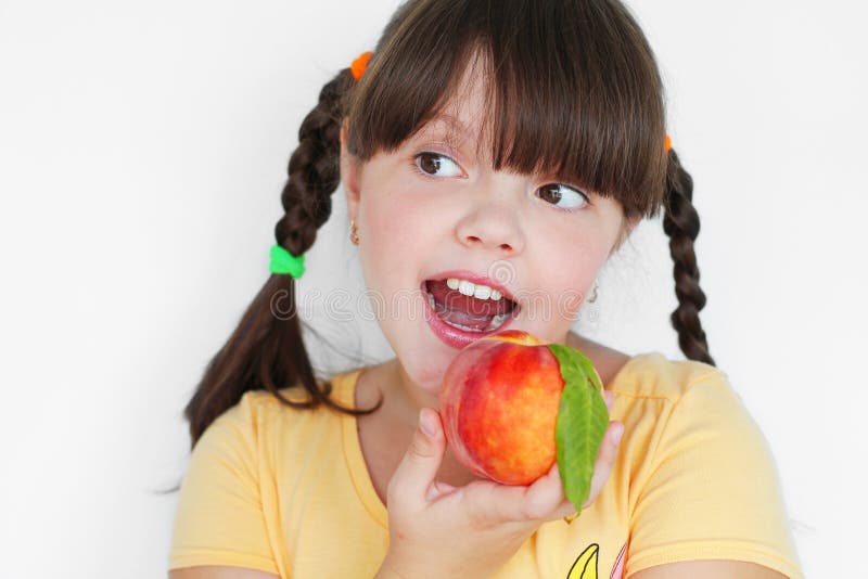 Funny child eating peach, portrait closeup