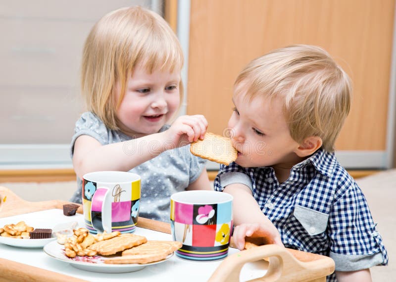 Funny children are eating dessert