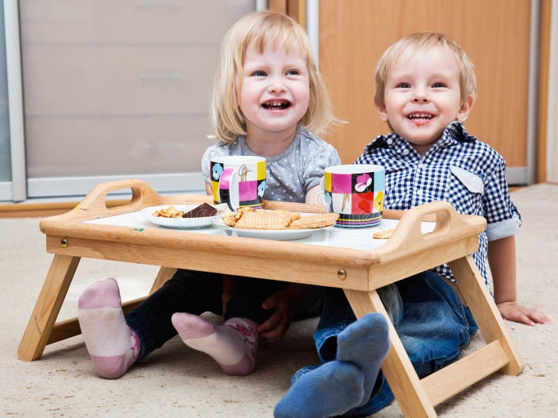 Funny children are eating dessert