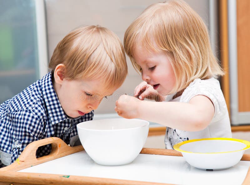 Funny children are eating dessert