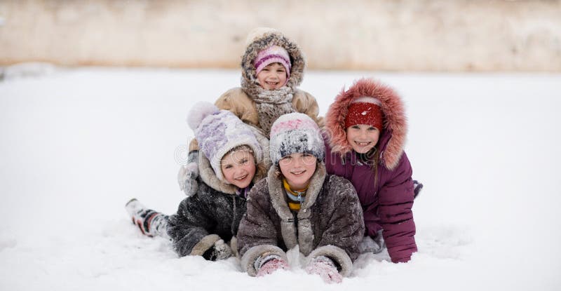 Funny children playing and laughing on snowy winter park
