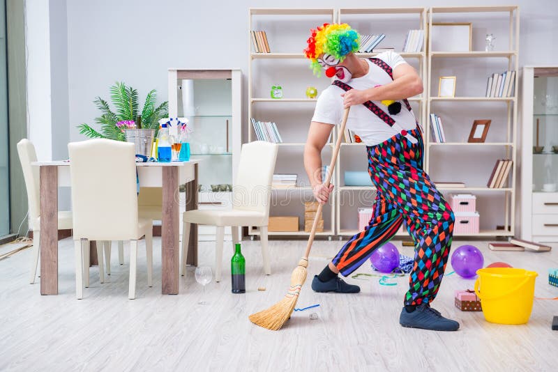 The funny clown doing cleaning at home stock images