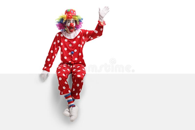 Funny clown sitting on a white panel and waving stock photo Funny clown sitting on a white panel and waving stock photo