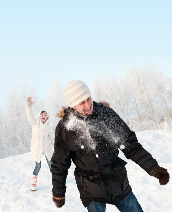 Funny couple playing snowballs