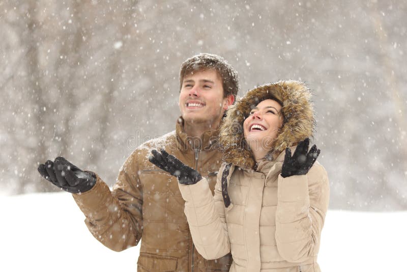 Funny couple watching snow in winter