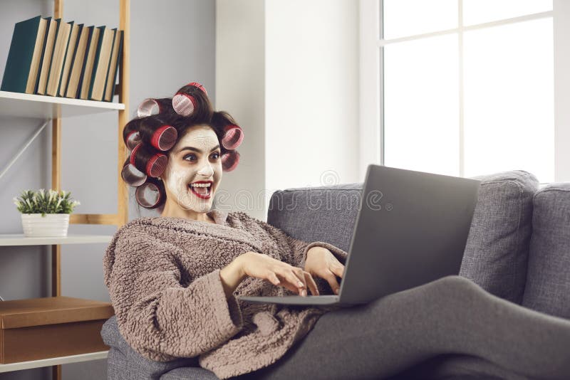 Funny crazy cheerful woman sitting on sofa and working online stock photos