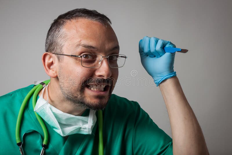 Funny crazy doctor holding a surgical knife stock photo
