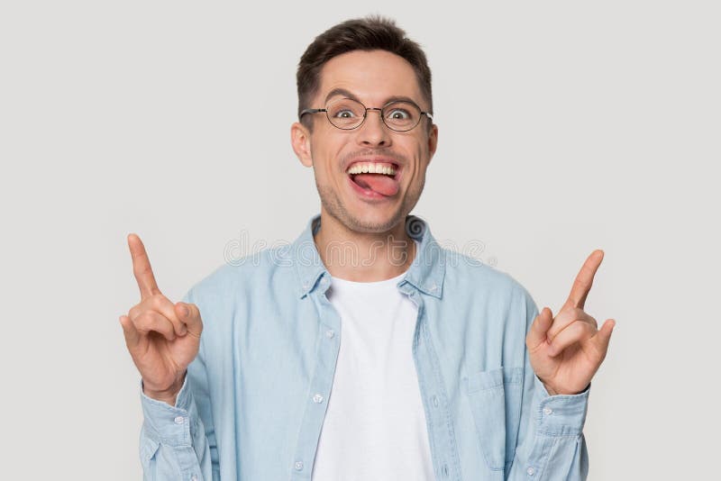 Funny crazy man showing rock-n-roll gesture with sticked out tongue. stock image