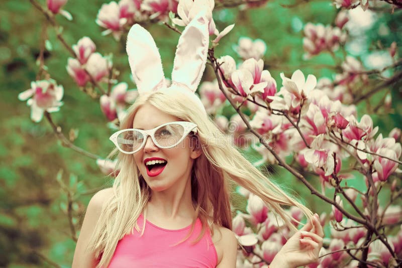 Funny crazy young woman in blossoming magnolia flower, spring. Happy easter. Sexy woman in bunny ears. Spring, nature royalty free stock photo