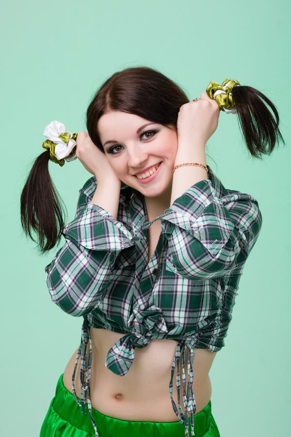 Funny cute smiling woman with pigtails on green