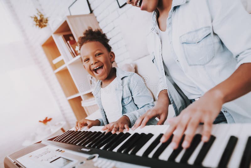 Funny Girl amd Happy Mother Play on Piano Together.