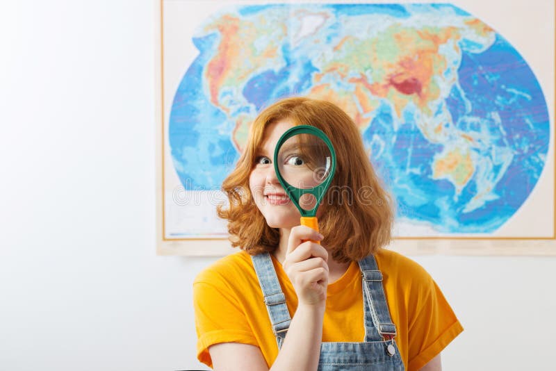 Funny girl stands at geographical map stock photography.