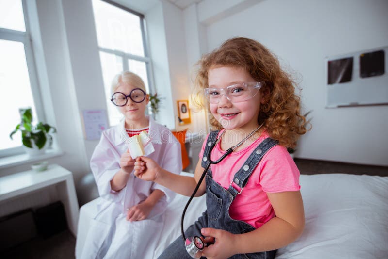 Funny girls wearing glasses eating glasses after playing together stock photo Funny girls wearing glasses eating glasses after playing together stock photo
